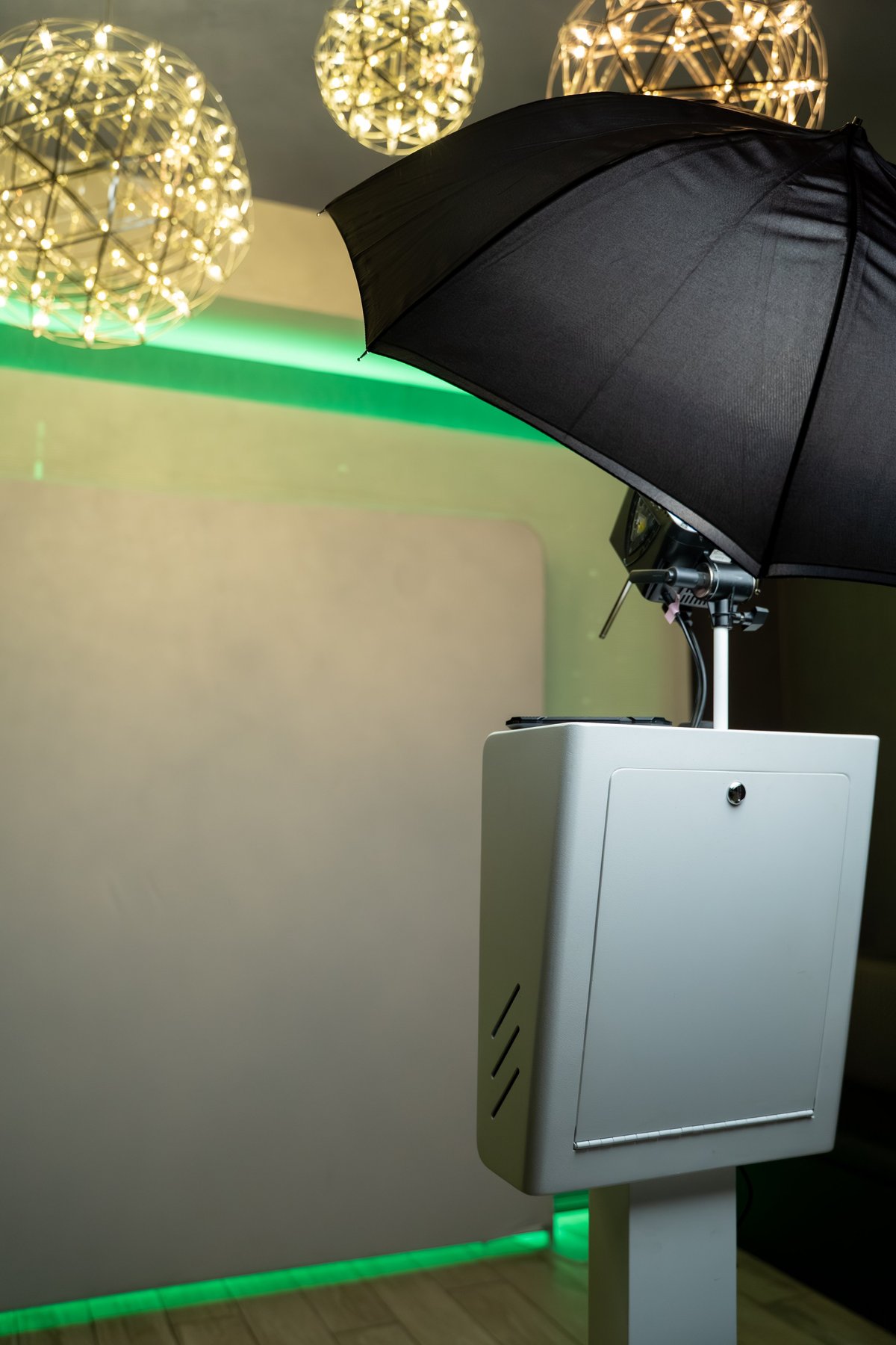 Photo booth setup with black umbrella light and backdrop
